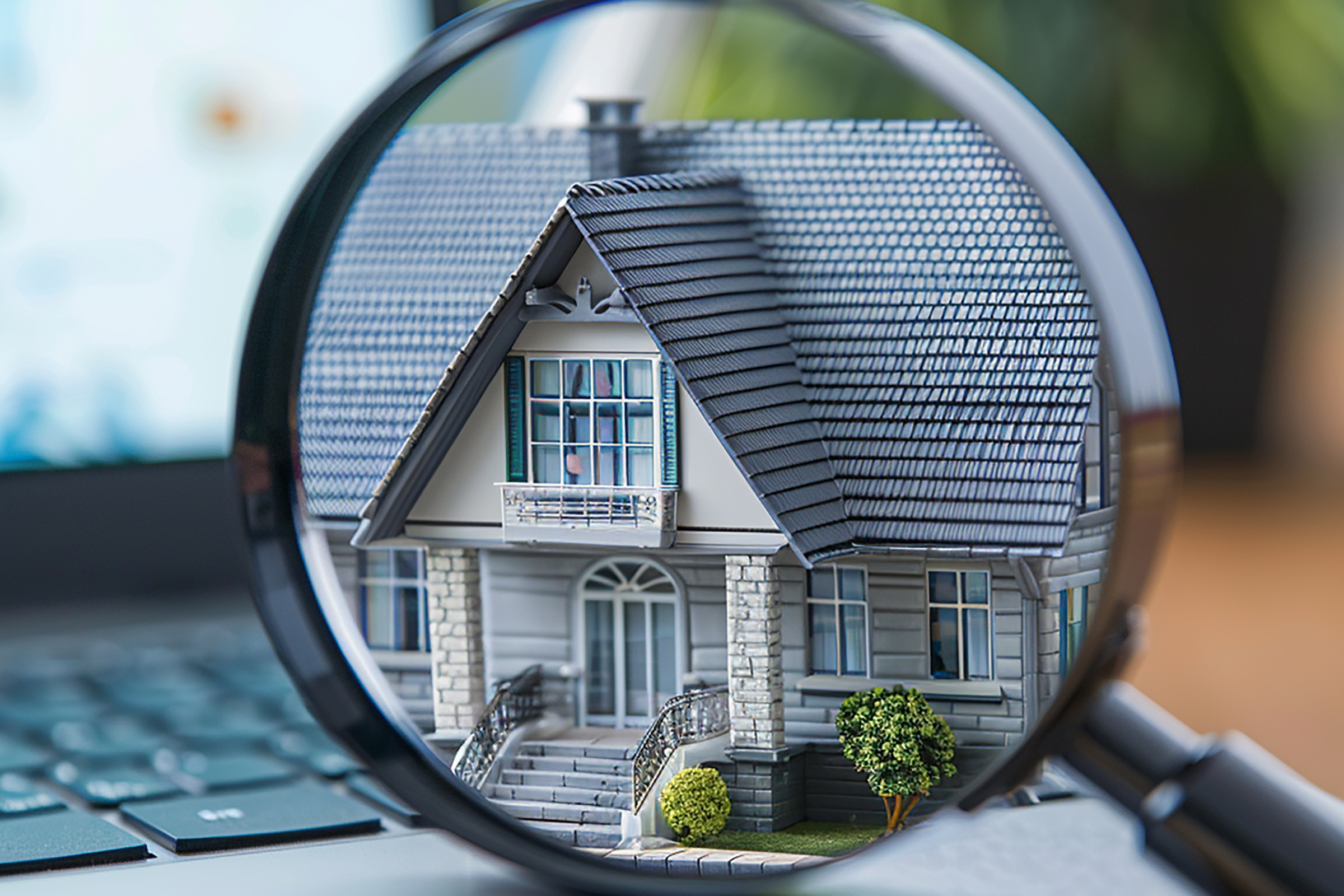 Close-up of house under magnifying glass during inspection