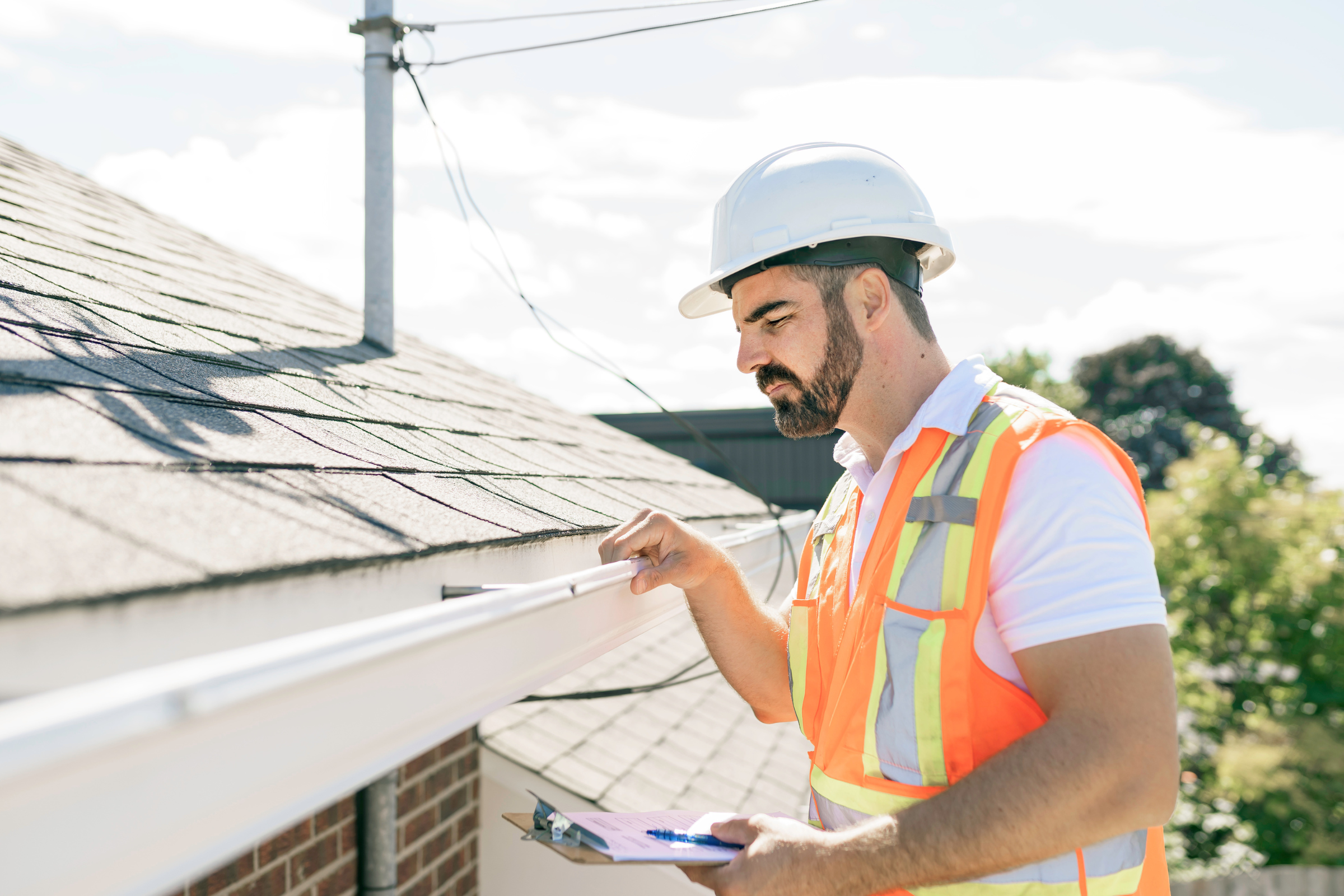 Home inspector checking roof and exterior system during 11th month warranty inspection in Los Angeles